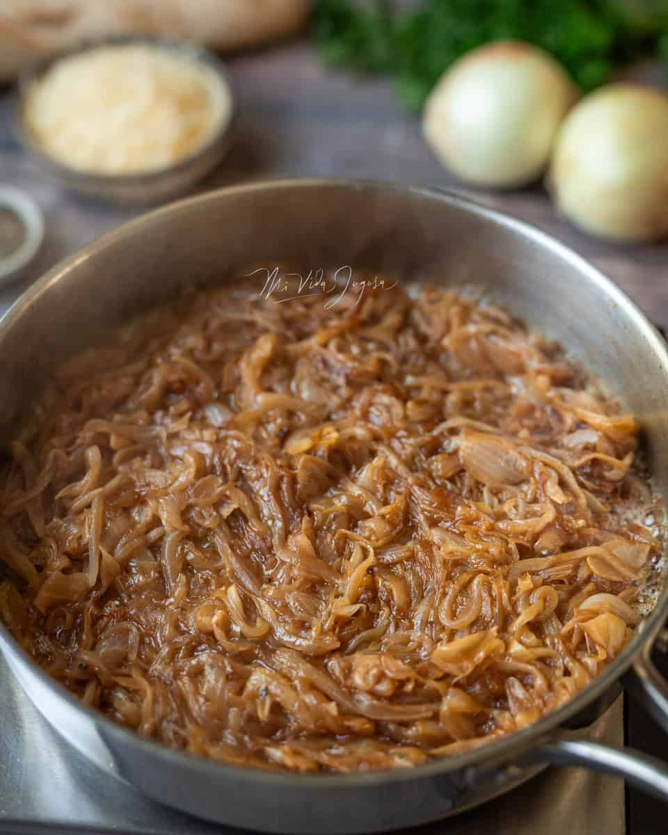 Un sarten de aluminio que muestra la cebolla caramelizada, muestra como se ha reducido el tamano de la cebolla