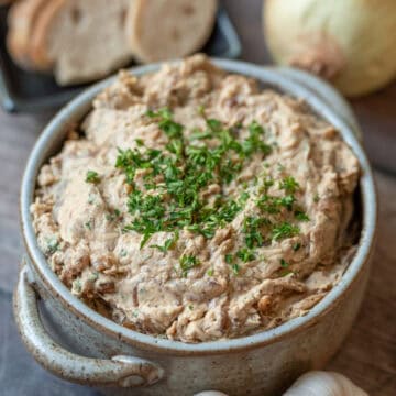 Un tazon redondo donde muestra el dip de cebolla caramelizado decorado con perejil por arriba