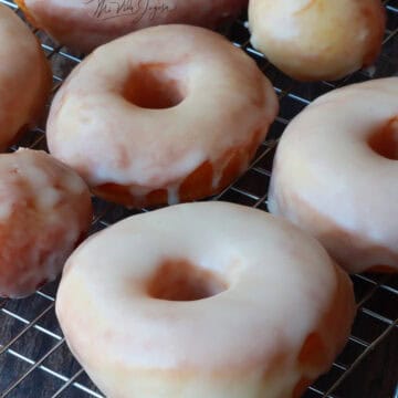 Donas listas y decoradas con glaseado, servidas sobre una bandeja cuadriculada