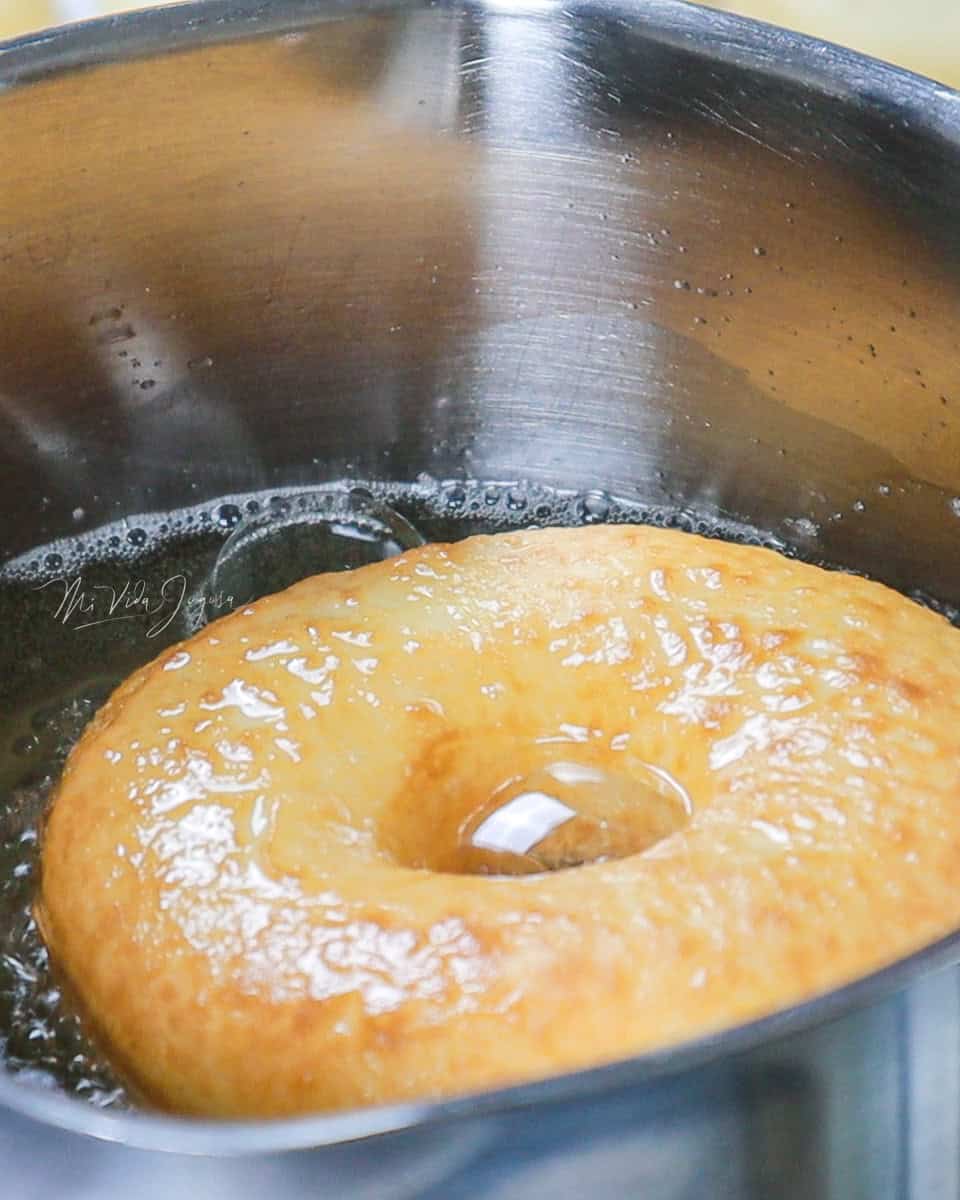 Dona friéndose en una olla pequeña con aceite