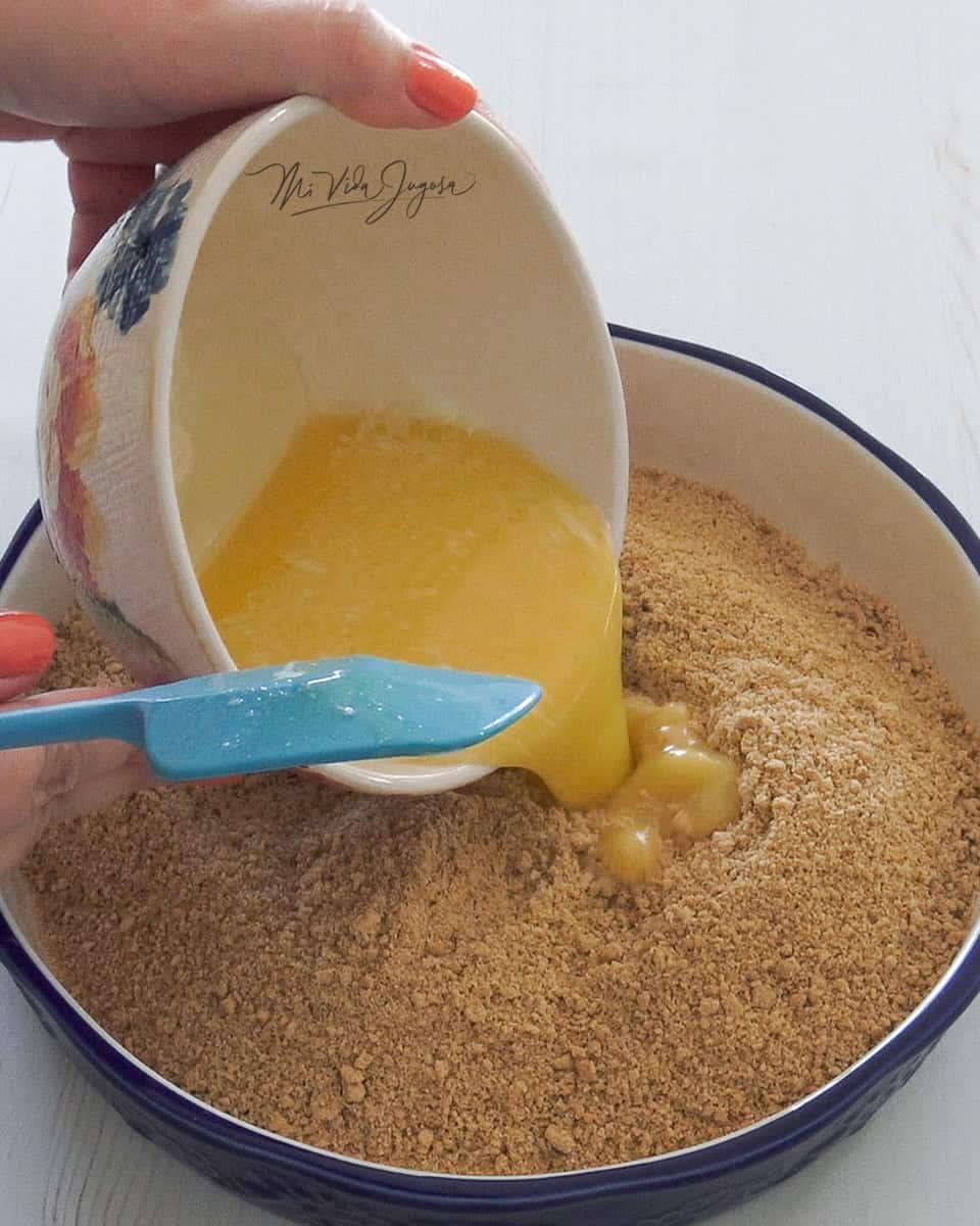 Molde de pay con galleta molida. Se le vierte mantequilla derretida a la galleta