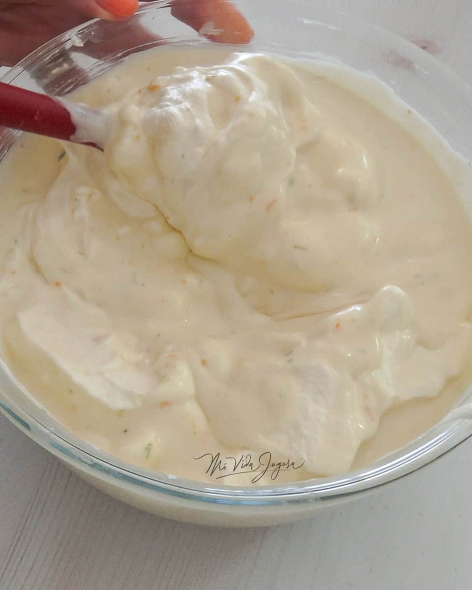 En un tazón transparente se revuelve la mezcla de queso crema, leche condensada y ralladuras de limón y jugos junto con la crema previamente batida