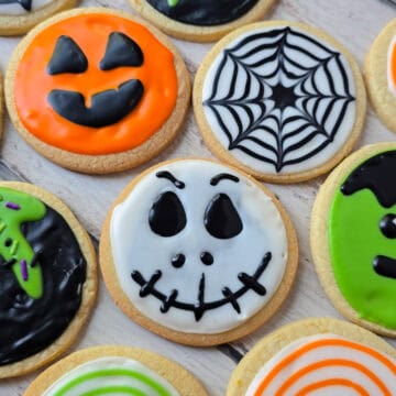 Se muestras diferentes galletas decoradas, una de elals con forma de calabaza de Halloween, otra de forma de telaraña, la siguiente de la cara de calavera de Jack del cadaver de la nocia, y la ultima de frankenstein.