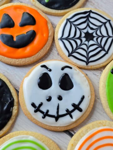 Se muestras diferentes galletas decoradas, una de elals con forma de calabaza de Halloween, otra de forma de telaraña, la siguiente de la cara de calavera de Jack del cadaver de la nocia, y la ultima de frankenstein.