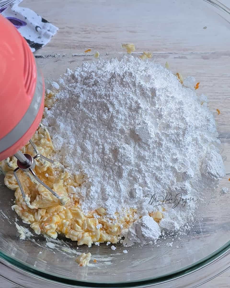 Tazon de vidrio conteniendo la mezcla de los ingredientes, se visualiza por encima de estos la azucar impalpable.
