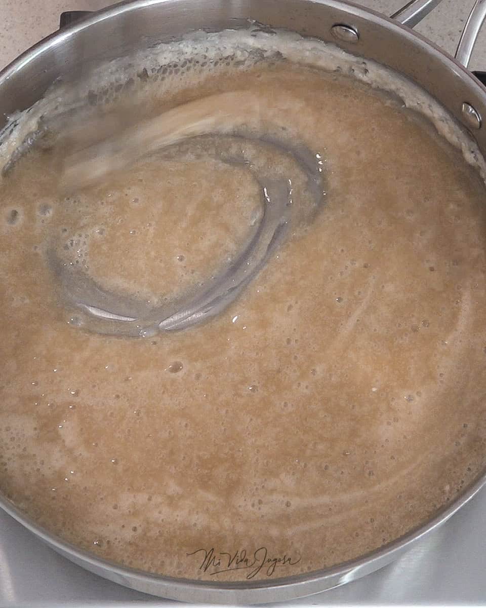 Se muestra la mezcla de agua, azúcar y mantequilla de color ligeramente cafe