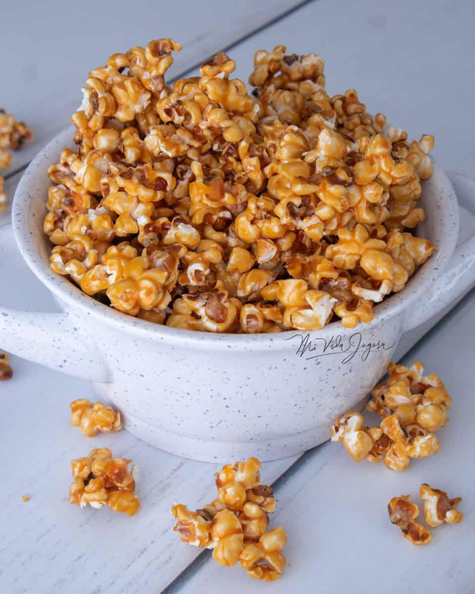 Se muestra un tazón de color blanco conteniendo palomitas de caramelo