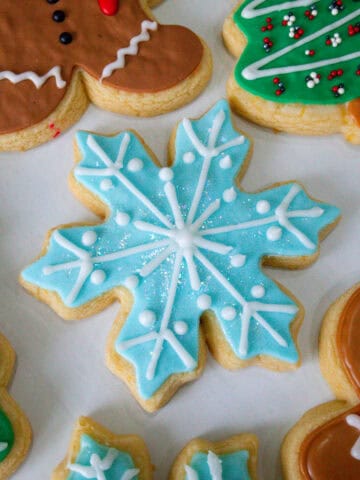 Se muestran varios diseños de galletas navideñas, incluyendo un muñeco de gengibre, un arbol de navidad, un copo de nieve