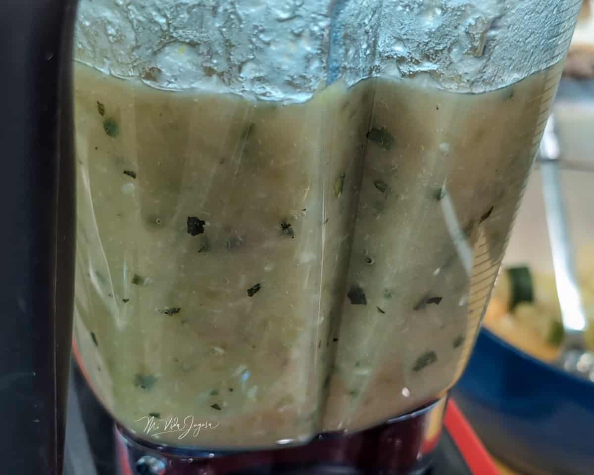 Un vaso de licuadora contiene un licuado de vegetales.