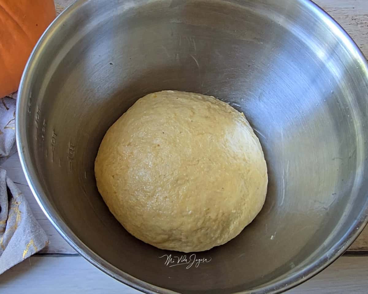 Un tazón con una bola de masa en su interior.