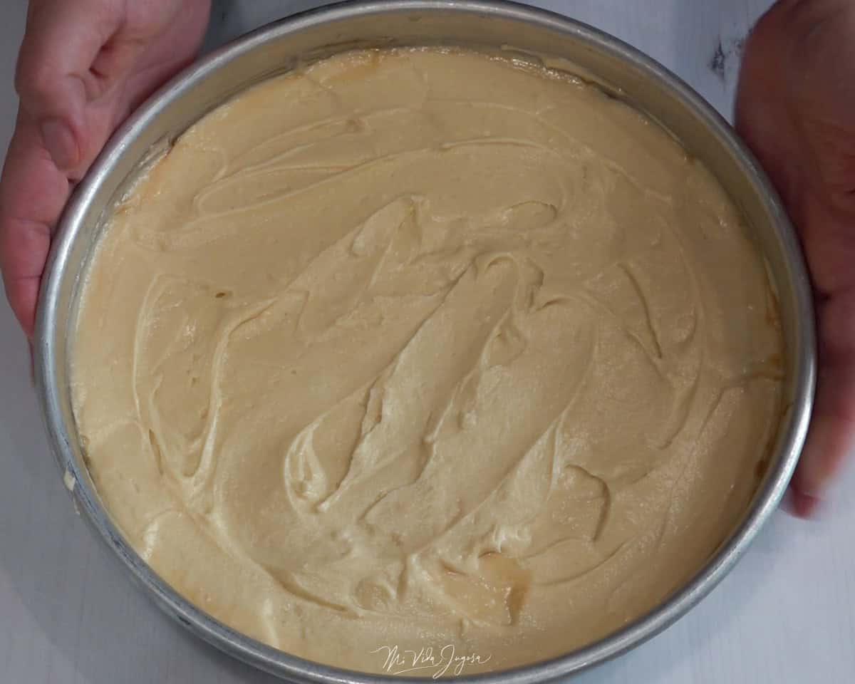 Un molde con la mezcla del bizcocho distribuida de manera pareja, lista para llevar al horno.